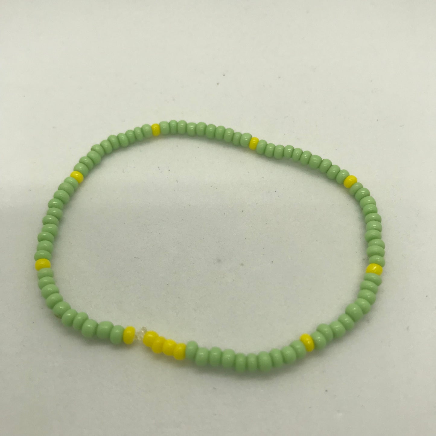 Elastisk armbånd med grønne og gule seedbeads