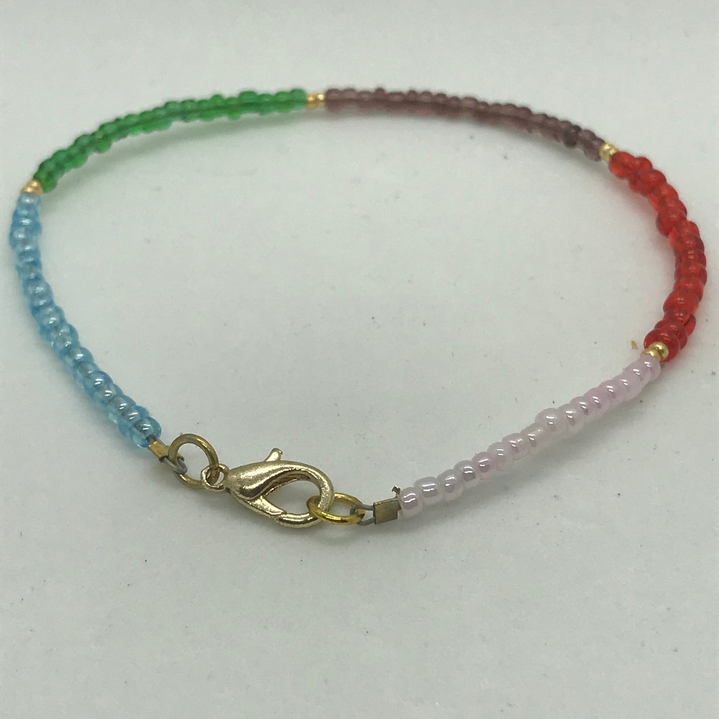 Armbånd på wire med forgyldte små perler og seedbeads