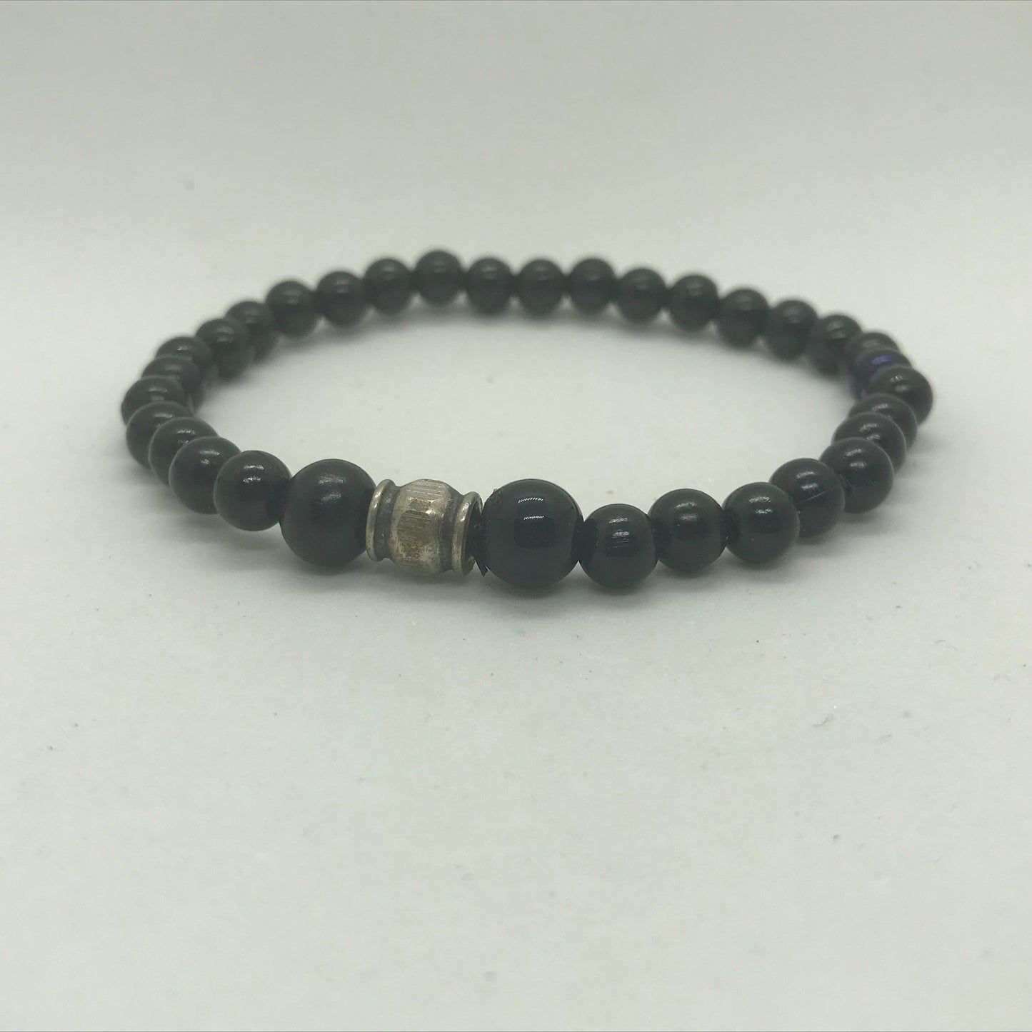 Armbånd i sorte perler og med metal perle