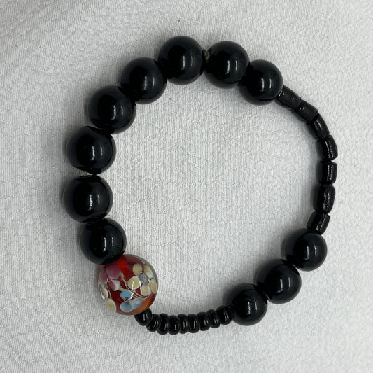 Sort armbånd med rød perle