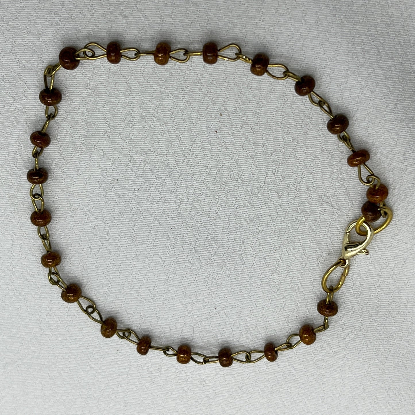 Armbånd i messingtråd og brune perler