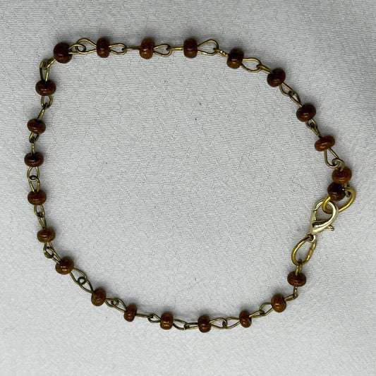 Armbånd i messingtråd og brune perler