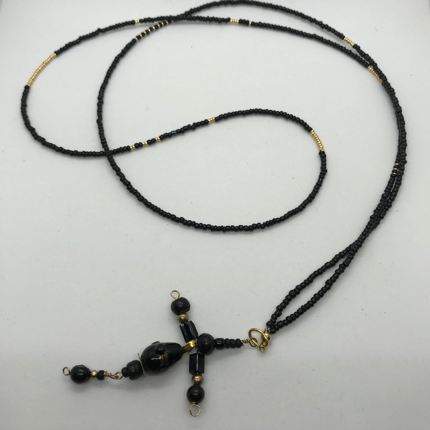 Halskæde med sorte seedbeads og med sort perlekors