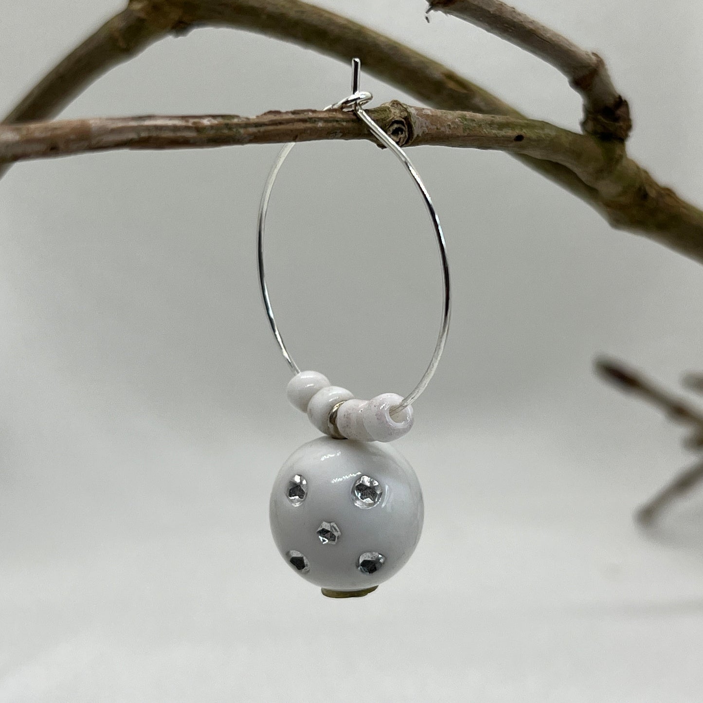 Single creol i sølv med hvid  sten