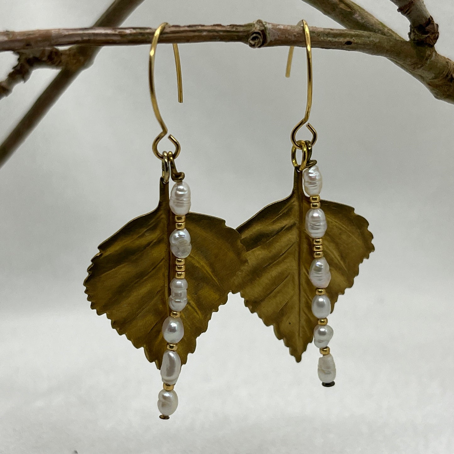 Øreringe i guldbelagt sølv med blade i messing