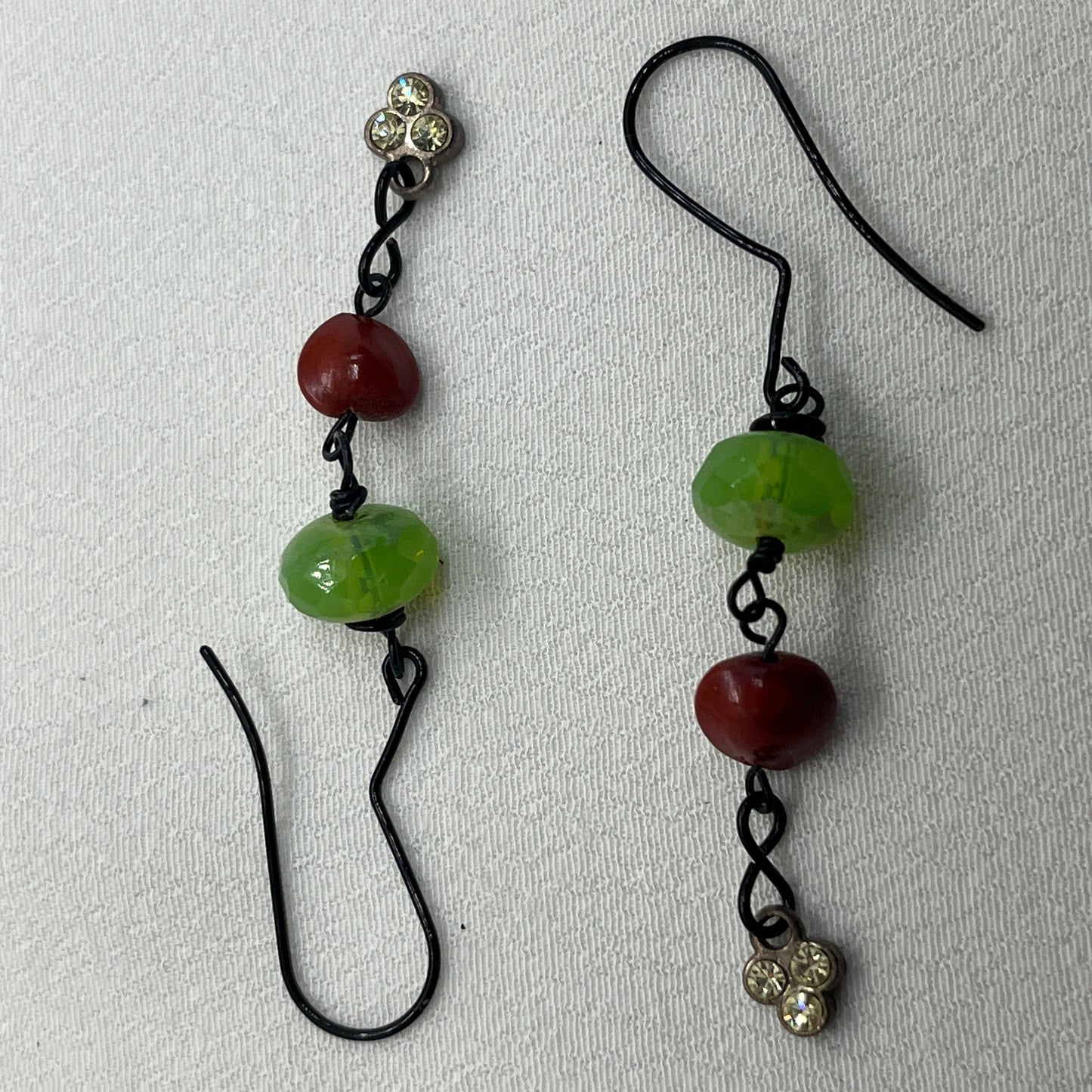 Sorte øreringe med grøn og rød perle