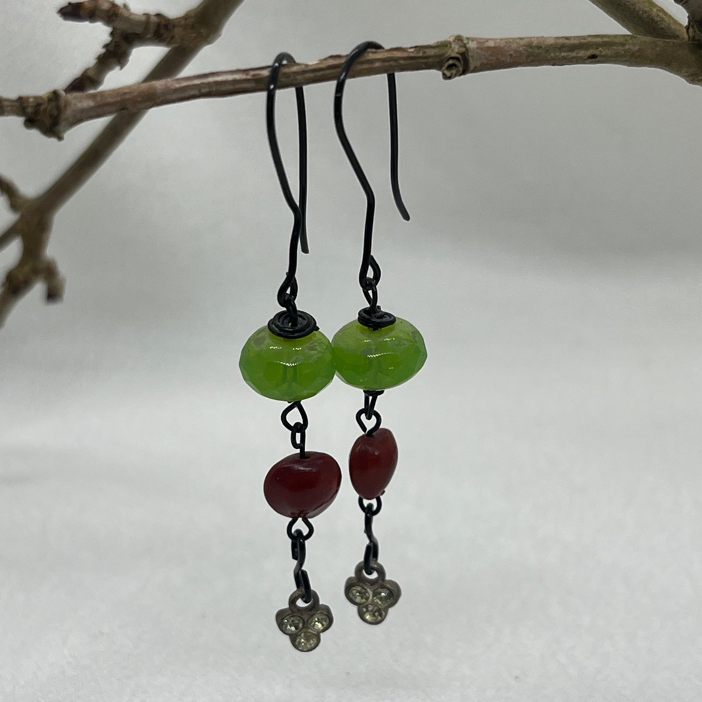 Sorte øreringe med grøn og rød perle