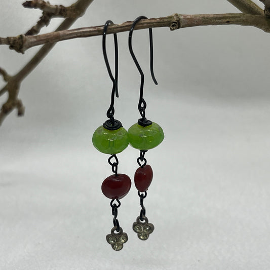 Sorte øreringe med grøn og rød perle