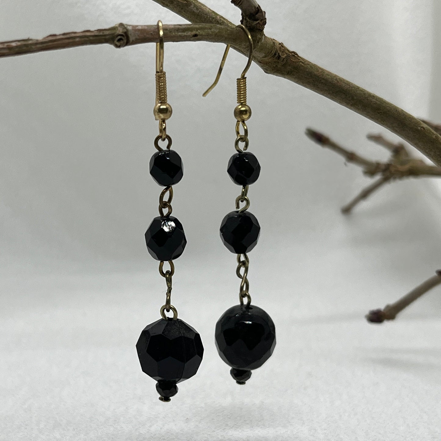 Messing øreringe med sorte perler