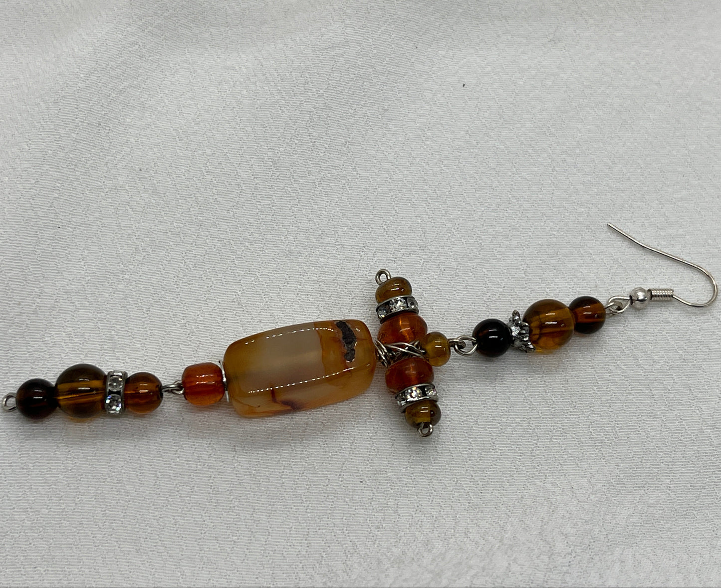 Single sølv ørering med kors i brune perler