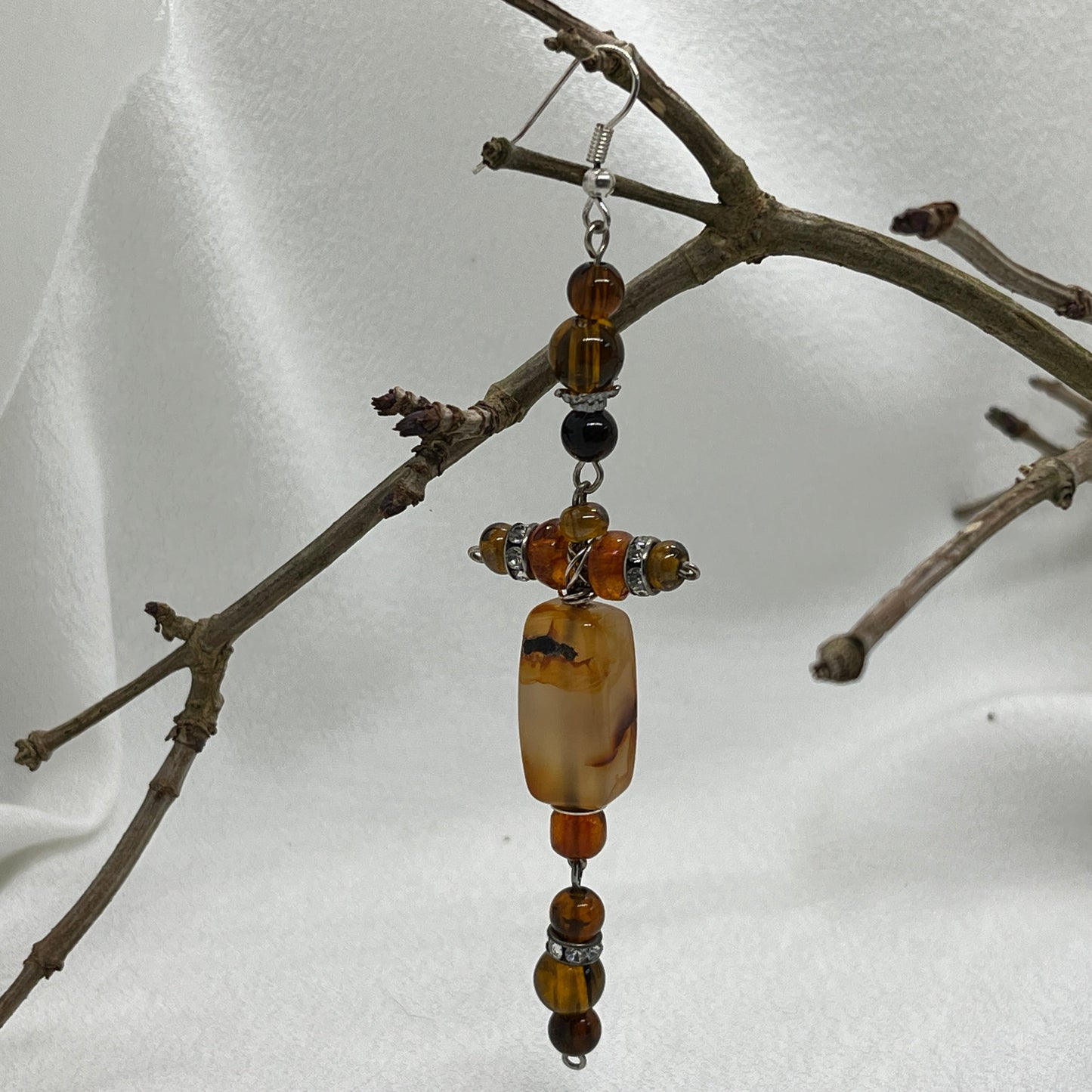 Single sølv ørering med kors i brune perler