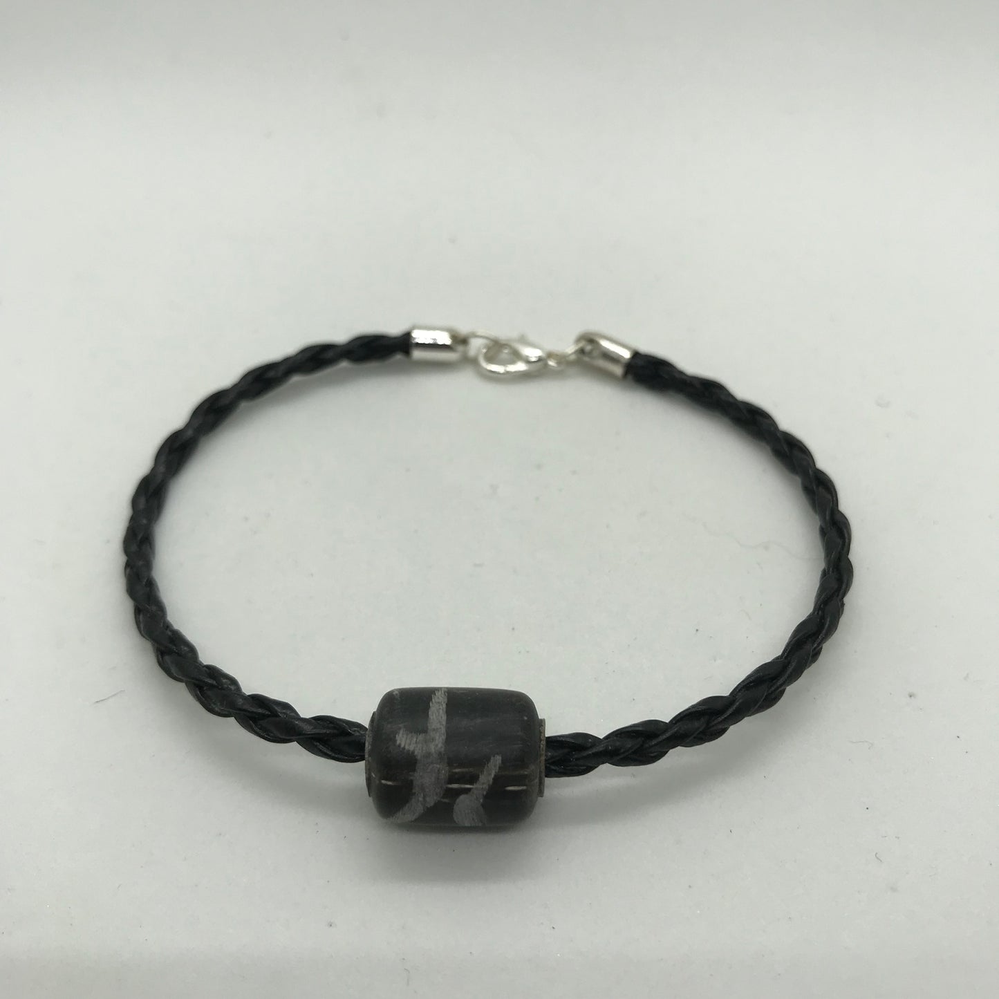 Flettet sort skind armbånd med sort perle