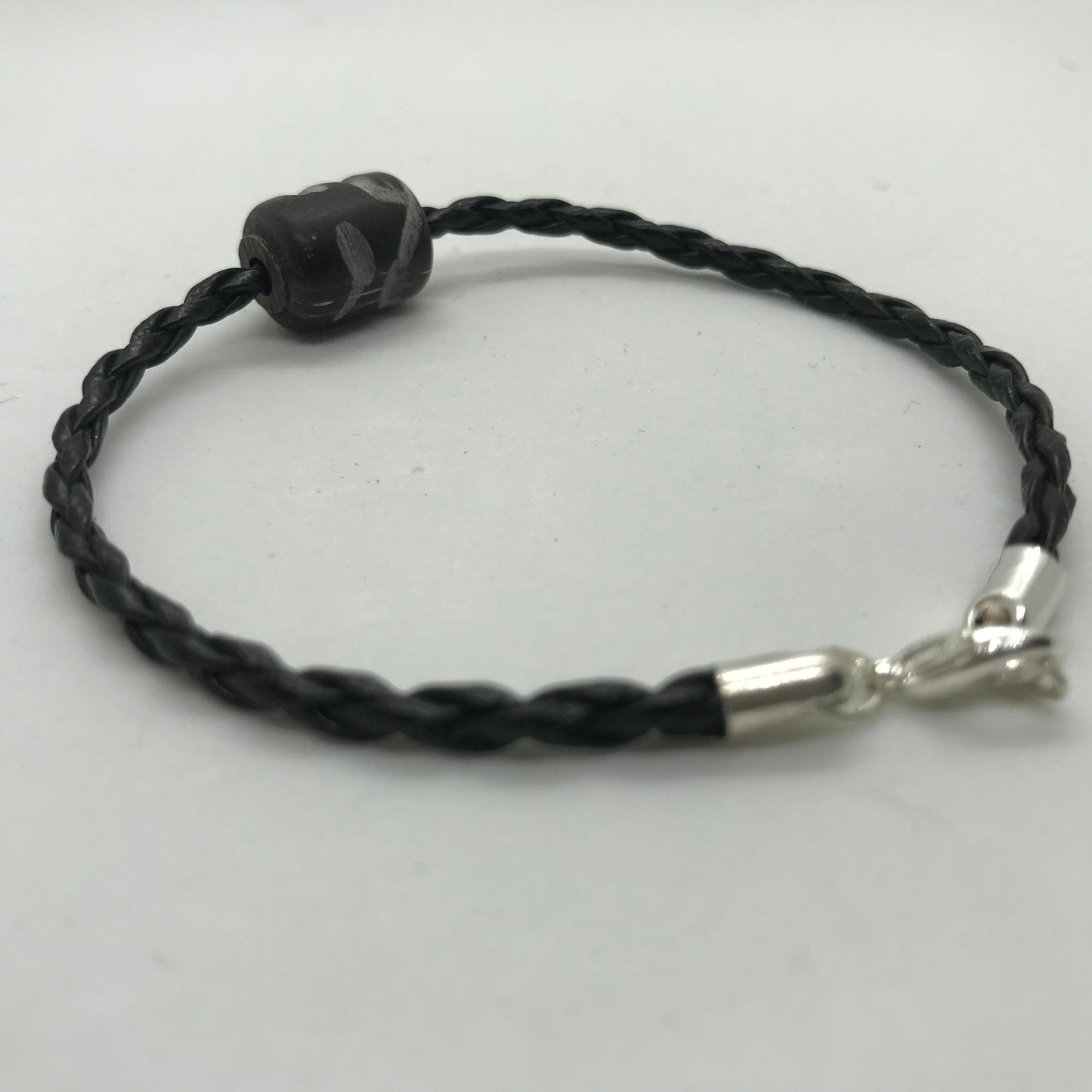 Flettet sort skind armbånd med sort perle