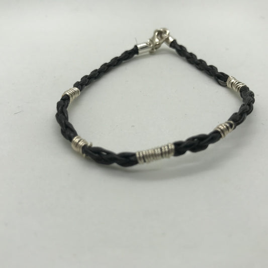 Sort armbånd i flettet skind med sølvviklinger