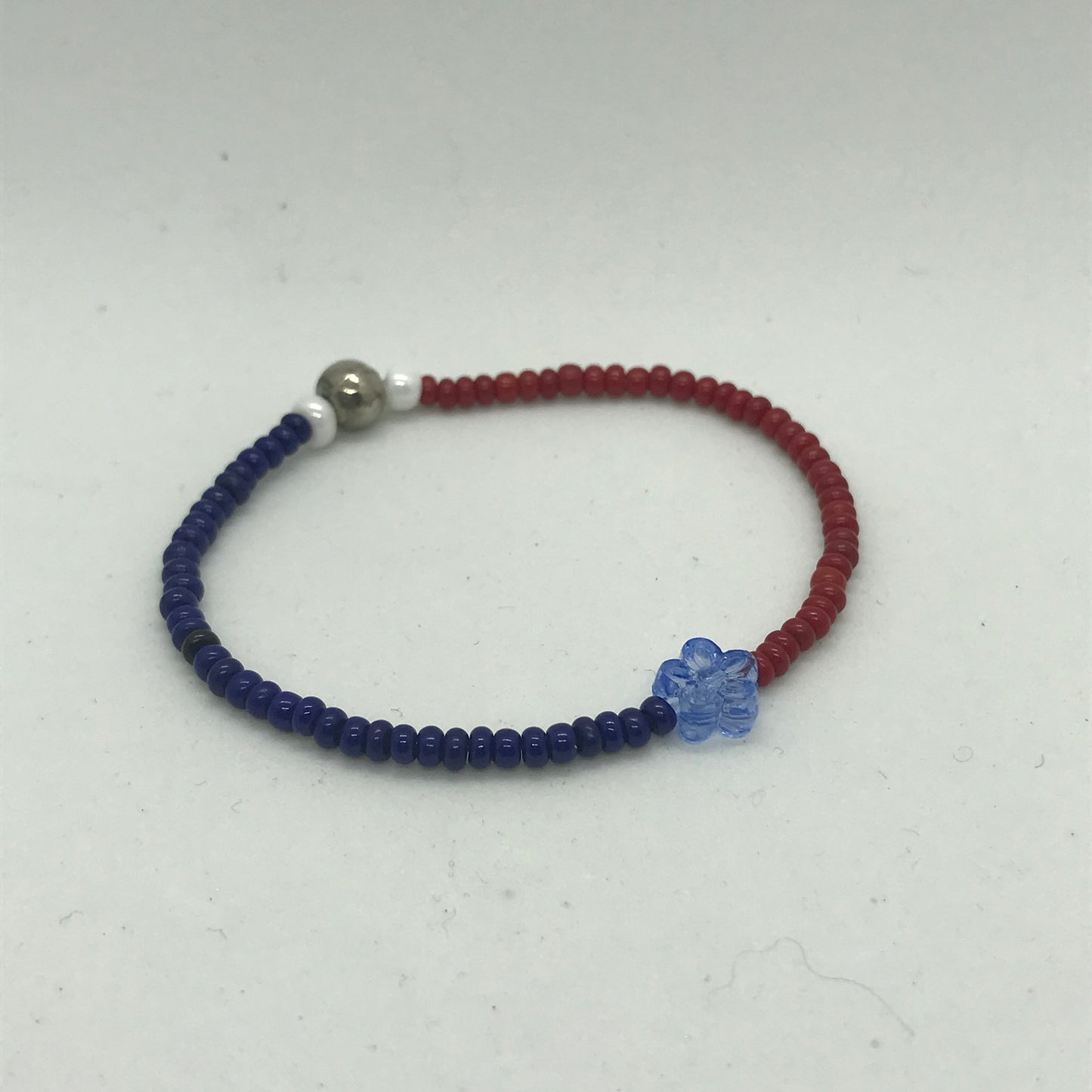 Blåt og rødt elastisk armbånd med seedbeads