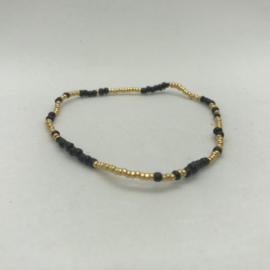 Elastisk armbånd med store sorte seedbeads med guld perler