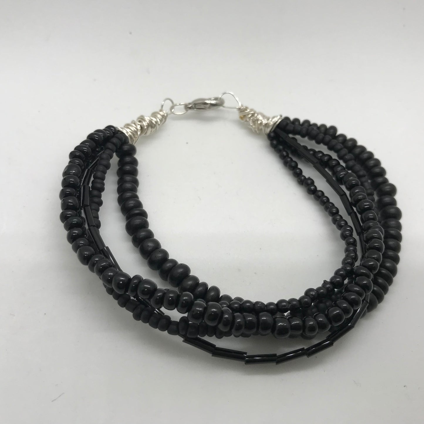 Armbånd med flere strenge sorte perler