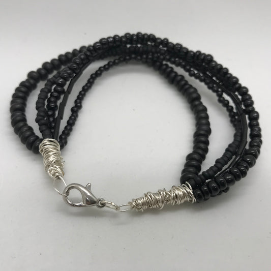 Armbånd med flere strenge sorte perler