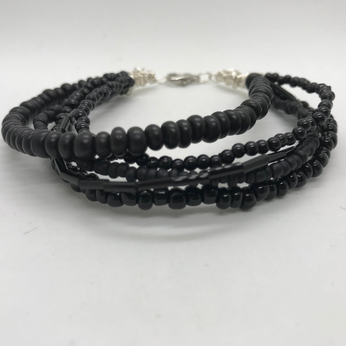 Armbånd med flere strenge sorte perler