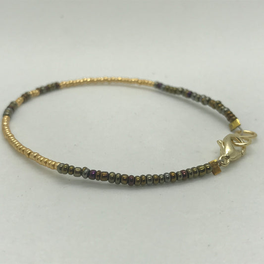Armbånd på wire med guld og brune seedbeads