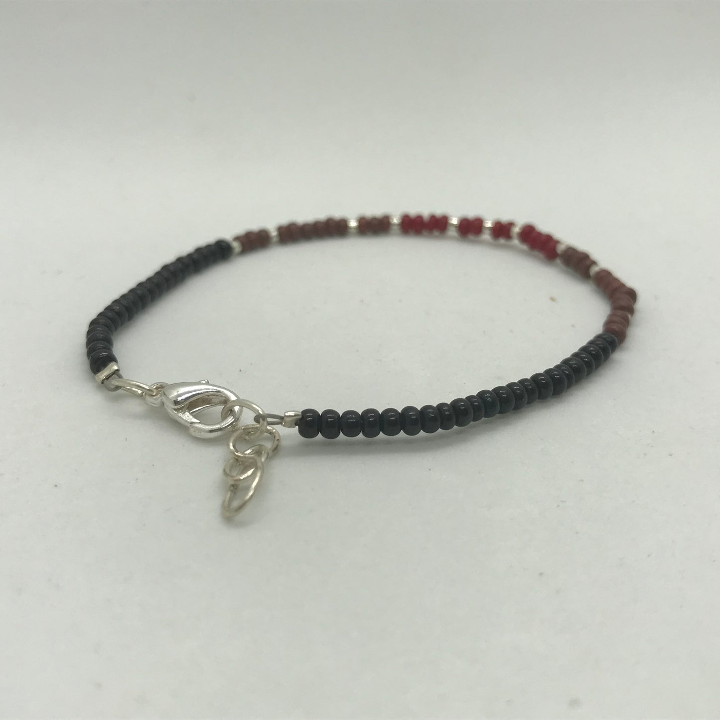 Armbånd på wire med sølv og sorte seedbeads