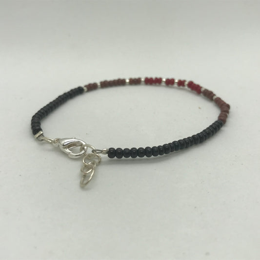 Armbånd på wire med sølv og sorte seedbeads