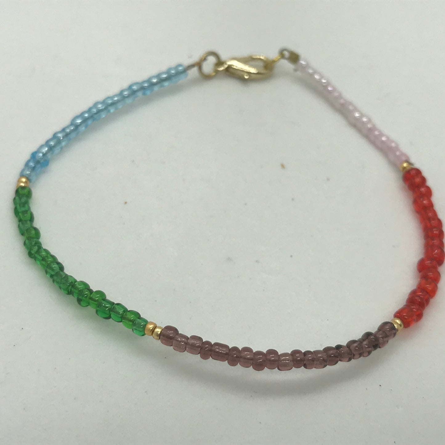 Armbånd på wire med forgyldte små perler og seedbeads