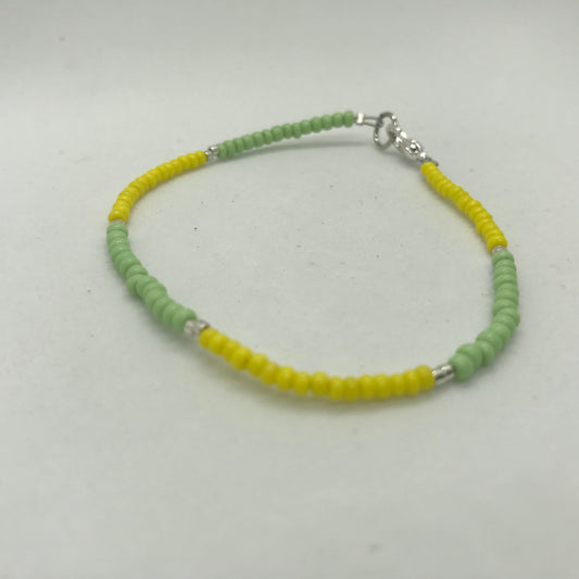Armbånd på wire med grønne og gule seedbeads