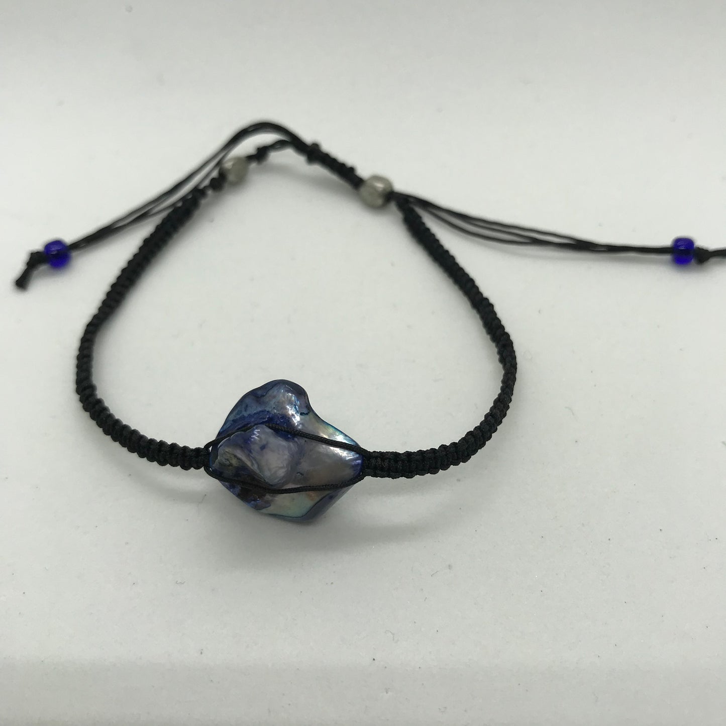 Sort knyttet armbånd med indfarvet perlemors perle