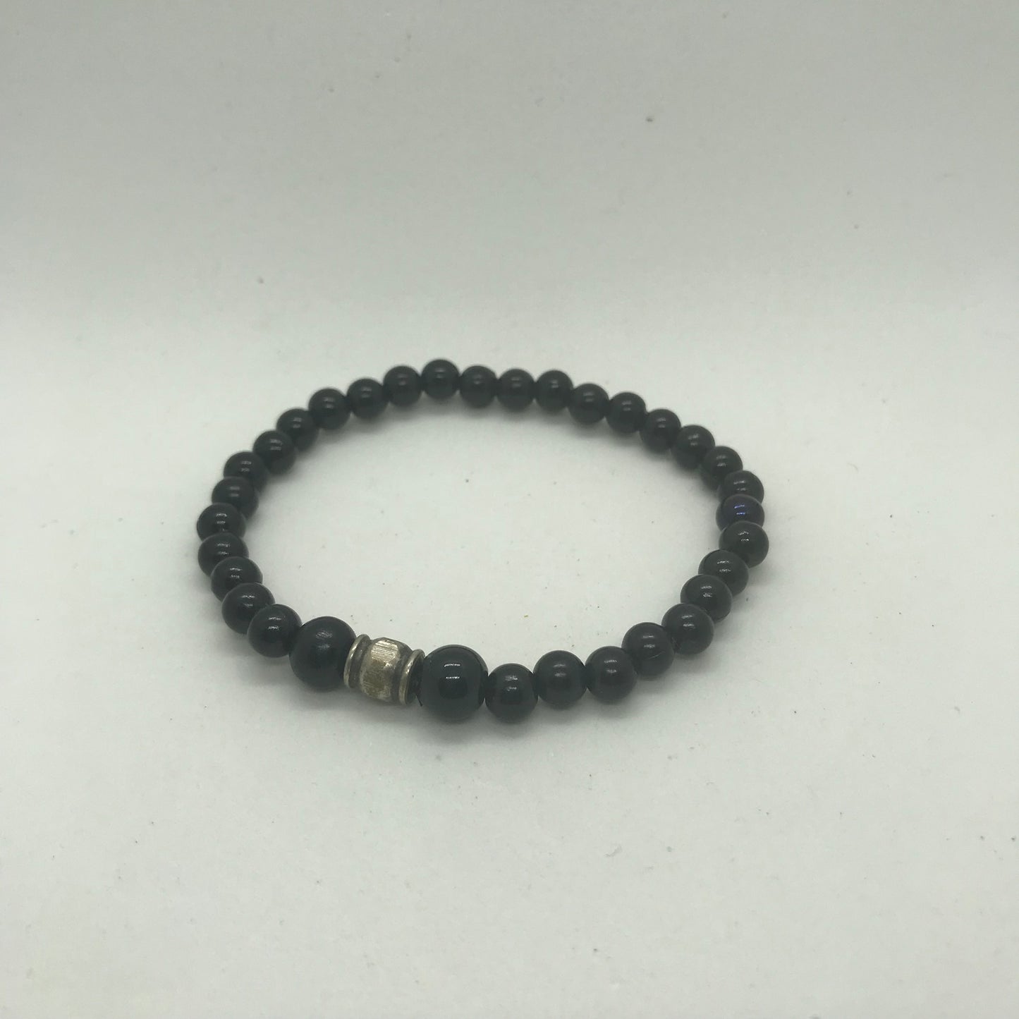 Armbånd i sorte perler og med metal perle