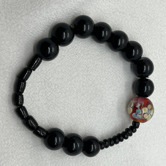 Sort armbånd med rød perle