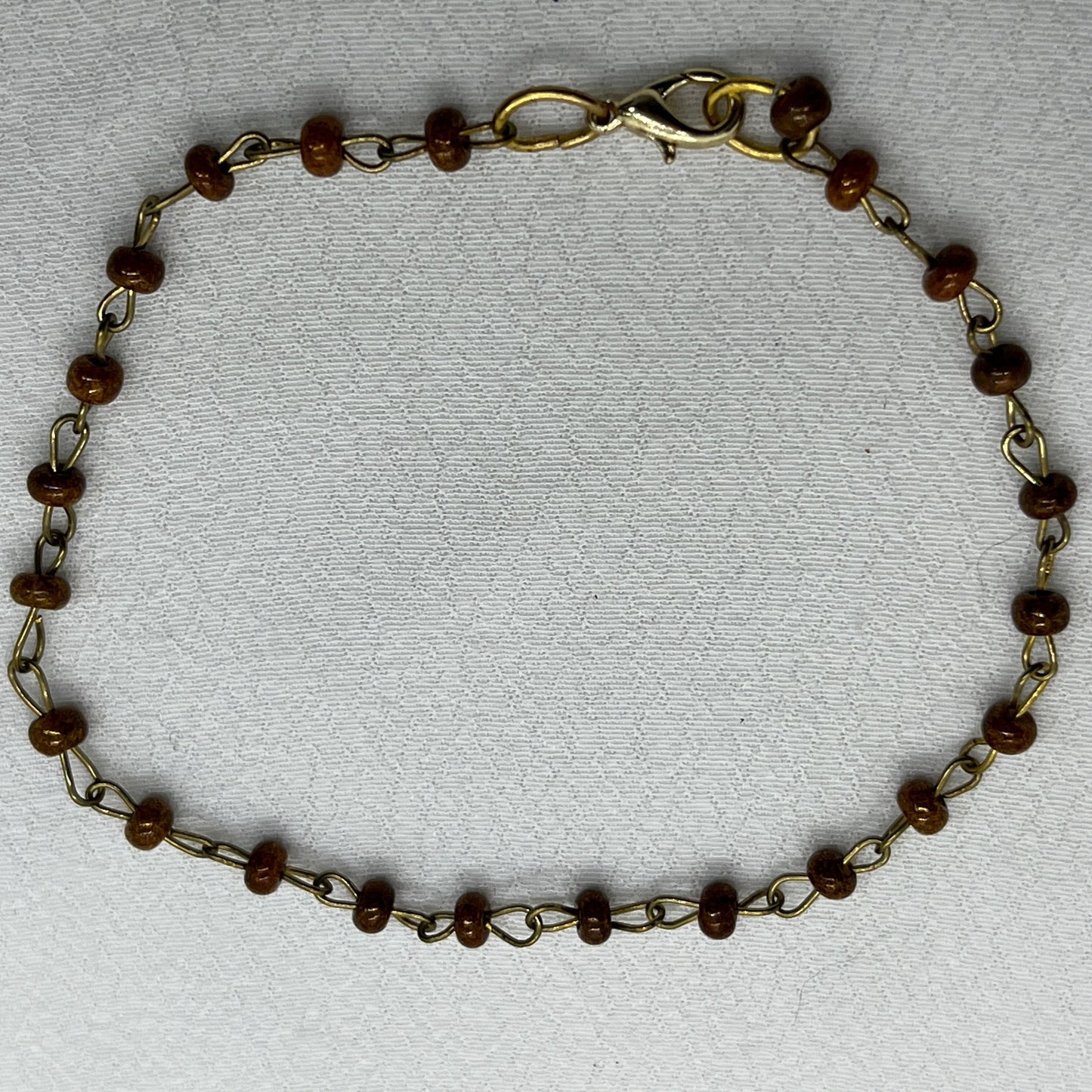 Armbånd i messingtråd og brune perler