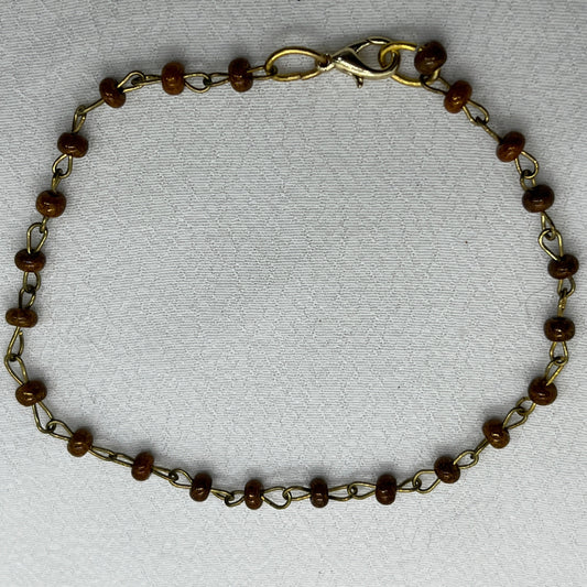 Armbånd i messingtråd og brune perler