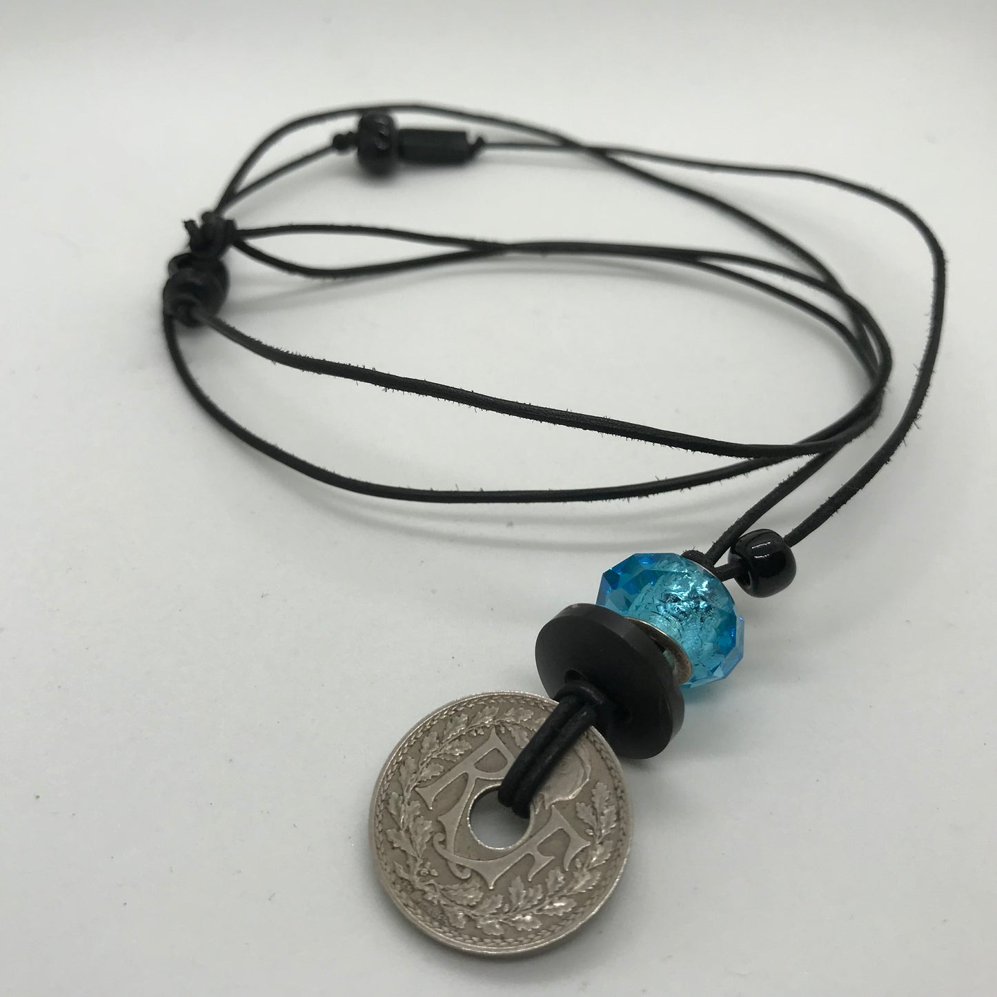 Halskæde med tynd skindsnor og blå perle