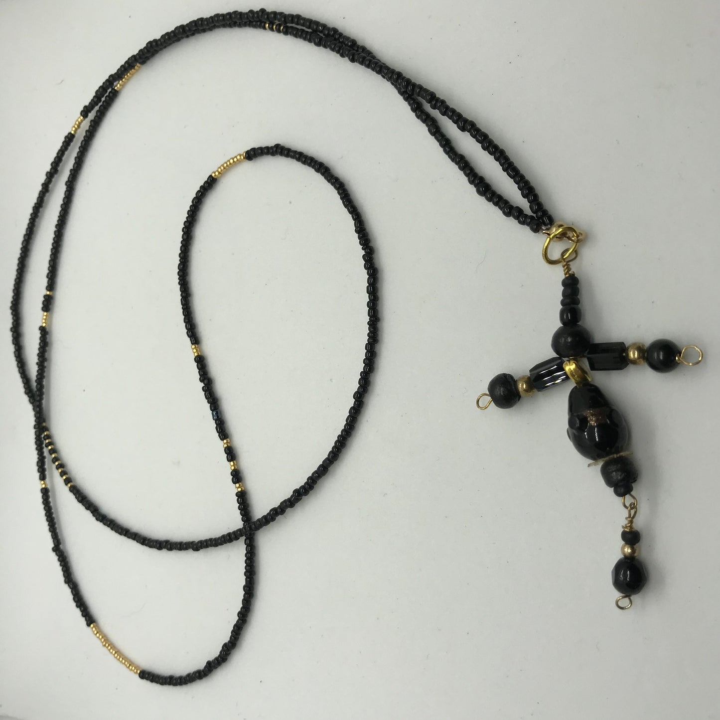 Halskæde med sorte seedbeads og med sort perlekors