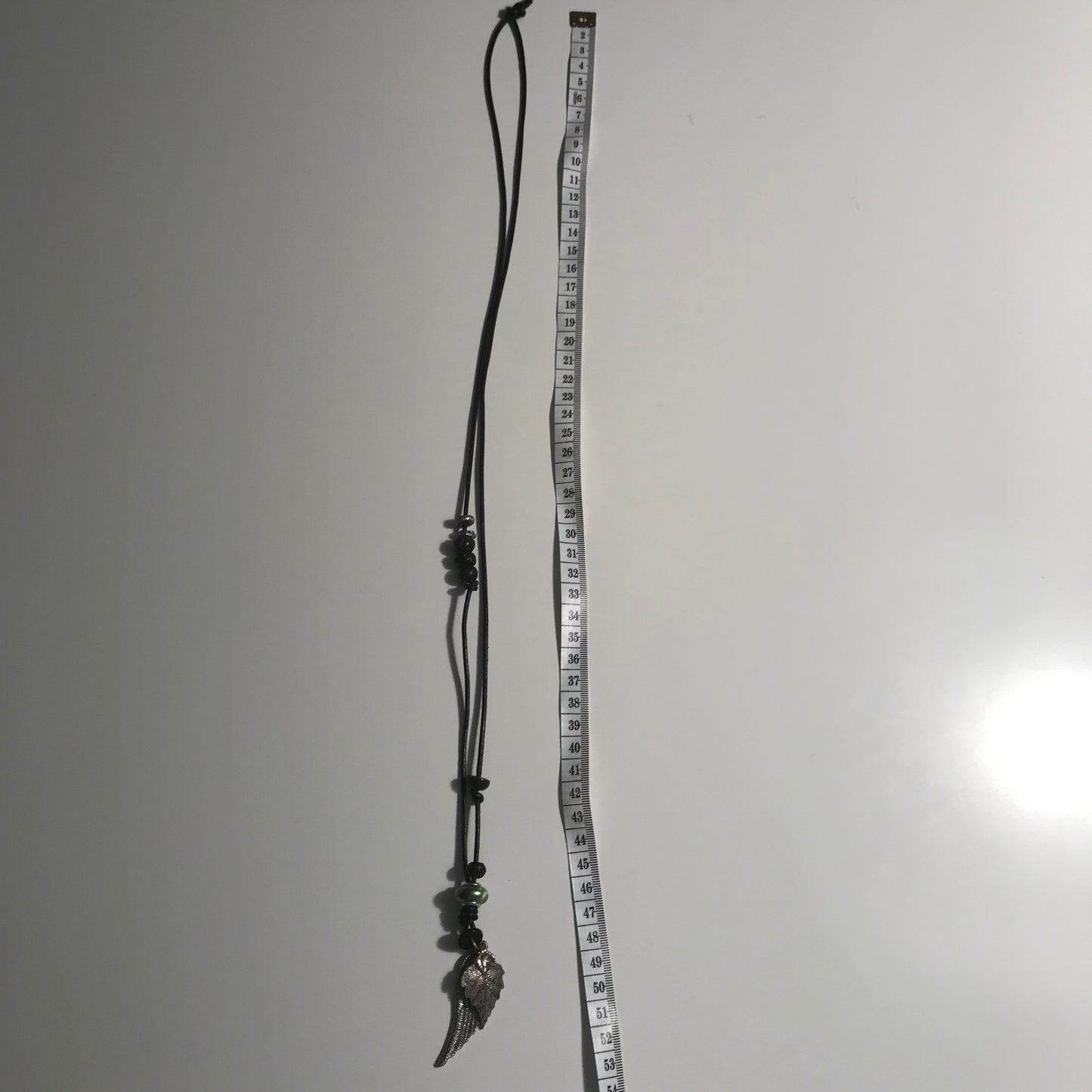 Halskæde i sort skind med sølvvinge