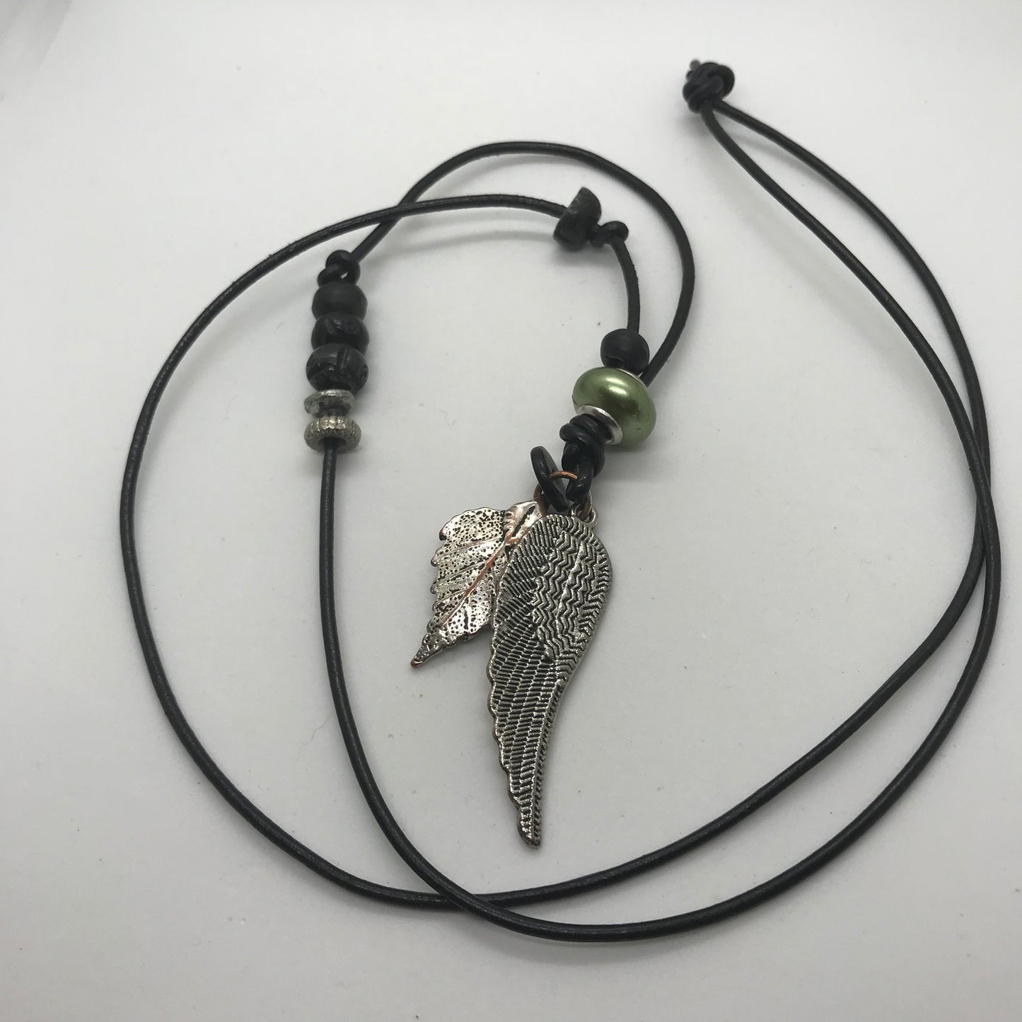 Halskæde i sort skind med sølvvinge